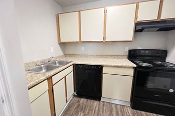 Kitchen with white cabinets, black appliances , sink